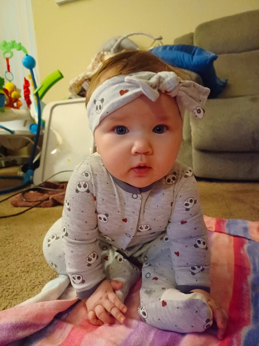 Bobbie joined the competition — help win amazing prizes! baby, baby_toddler_clothing, blue, cap, cheek, child, comfort, couch, eye, fashion_accessory, flooring, happy, headband, headpiece, headwear, linens, pattern, person, room, sitting