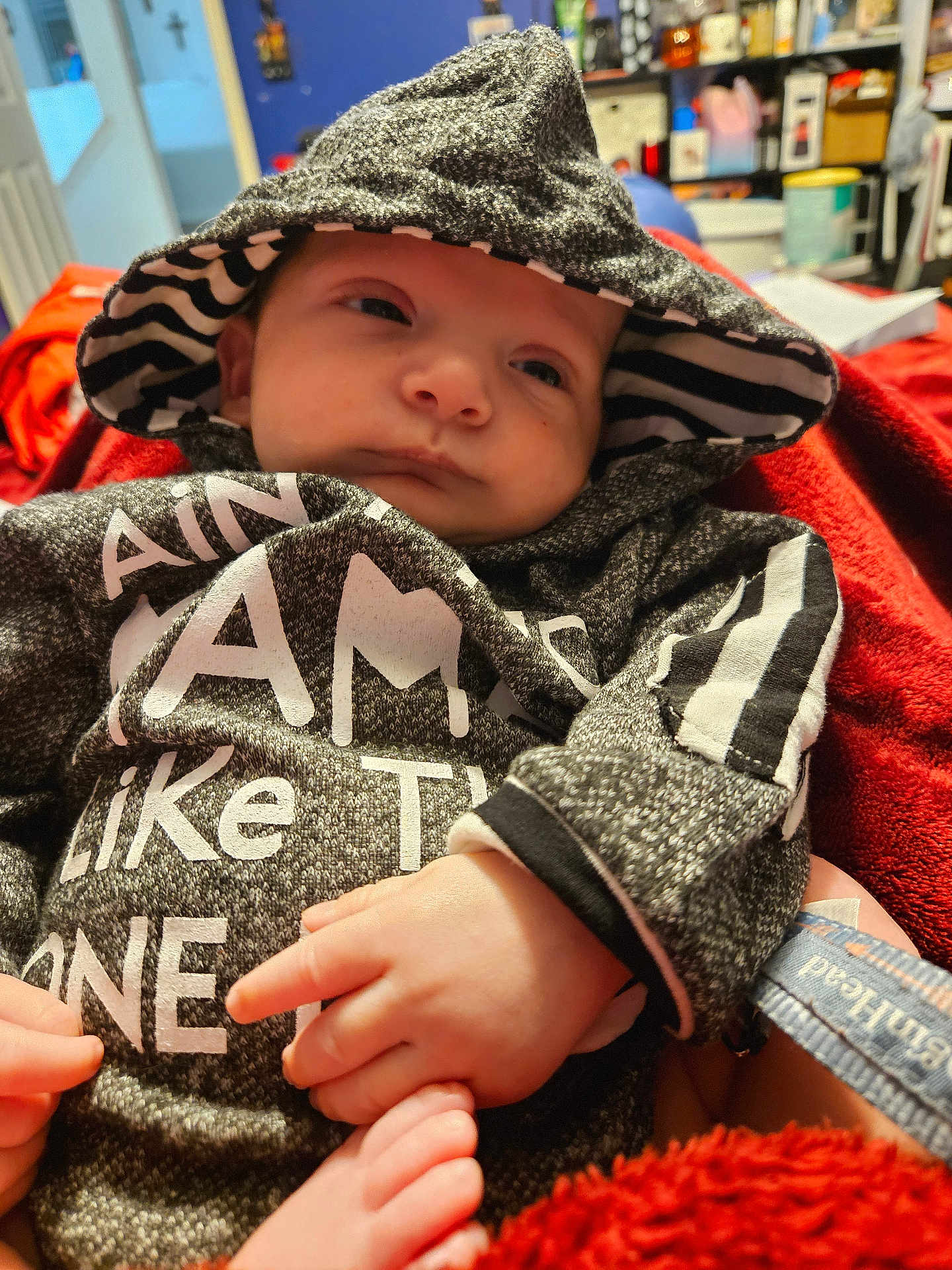 Ezekiel Edward joined the competition — help win amazing prizes! baby, hood, sweater, striped, hand, foot, blanket, red, indoor, clothing, infant, person, portrait, cute, face, small, relaxed, cozy, warm, expression