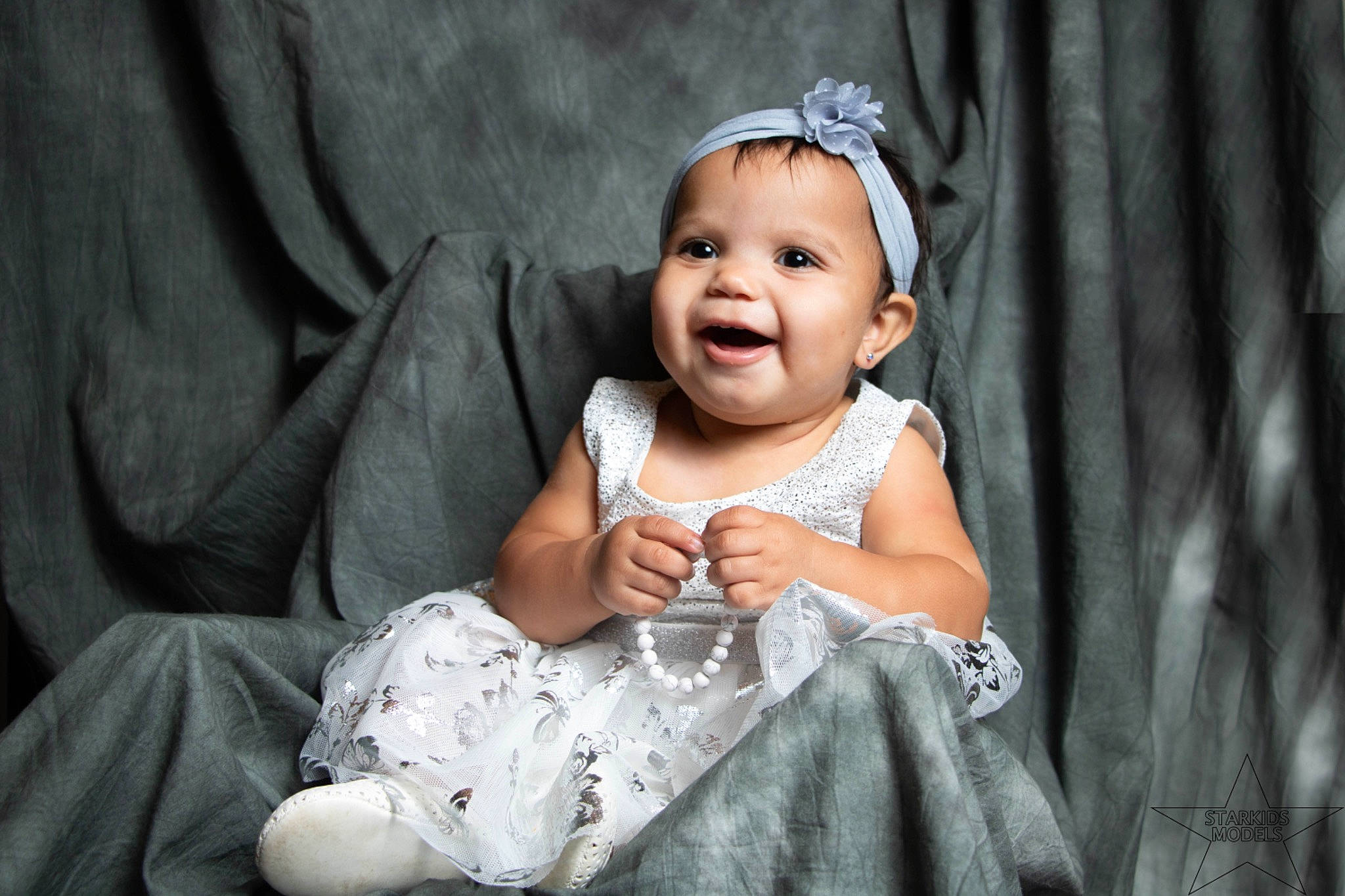 Dmia is registered to the contest to win money with this photo: baby, baby_toddler_clothing, child, curtain, dress, eye, flash_photography, fun, grass, grey, happy, head, headpiece, iris, monochrome_photography, person, skin, smile, standing, textile