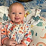 Hope joined the competition — help win amazing prizes! baby, child, smiling, tongue_out, onesie, floral_pattern, blanket, pillow, cat, bed, indoor, cute, playful, happy, infant, person, face, head, hands, resting