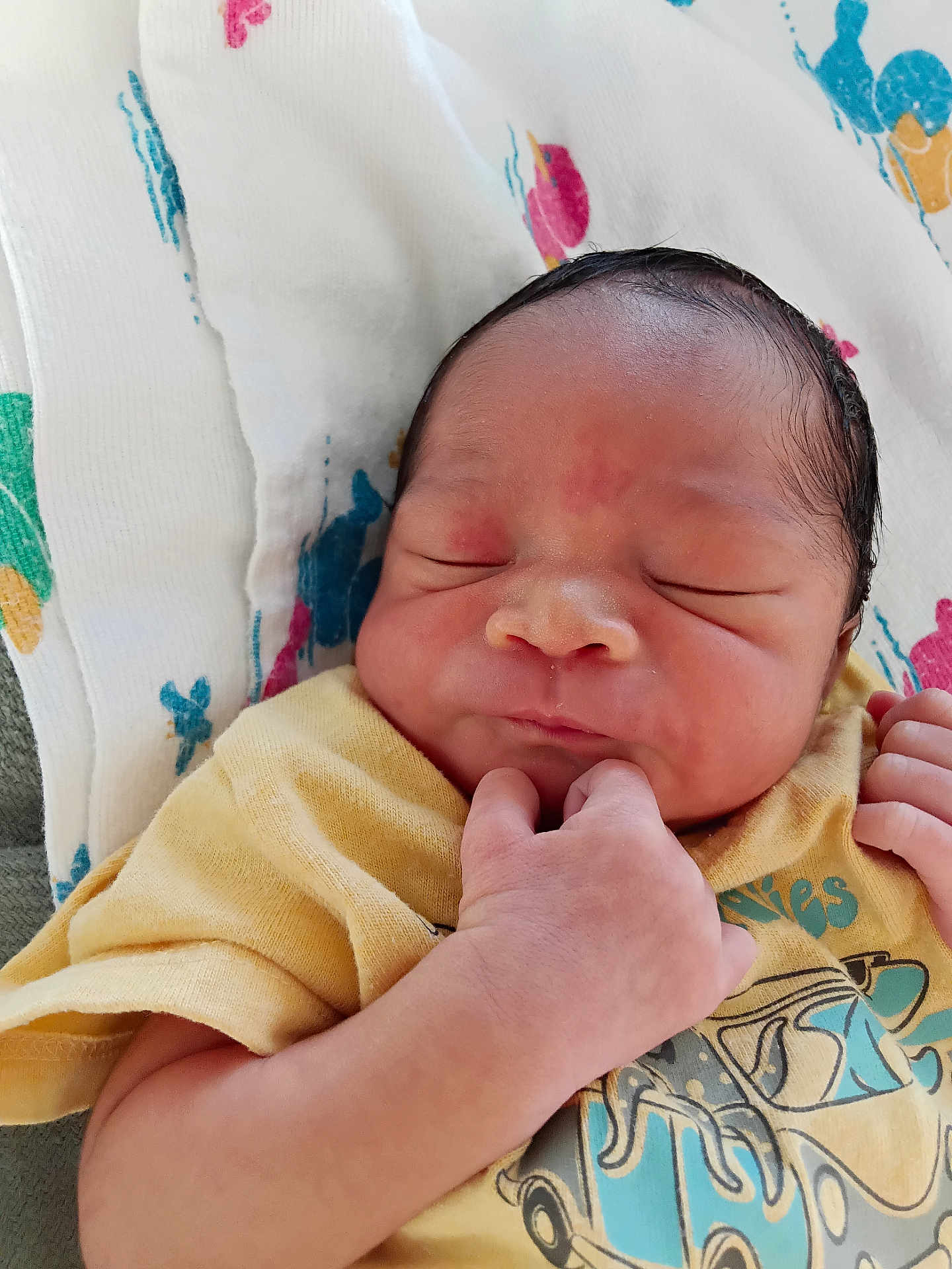 Mazir is registered to the contest to win money with this photo: newborn, baby, infant, sleeping, face, hand, yellow_shirt, clothing, blanket, pattern, skin, portrait, cute, resting, peaceful, child, human, indoors, closeup, small_hands