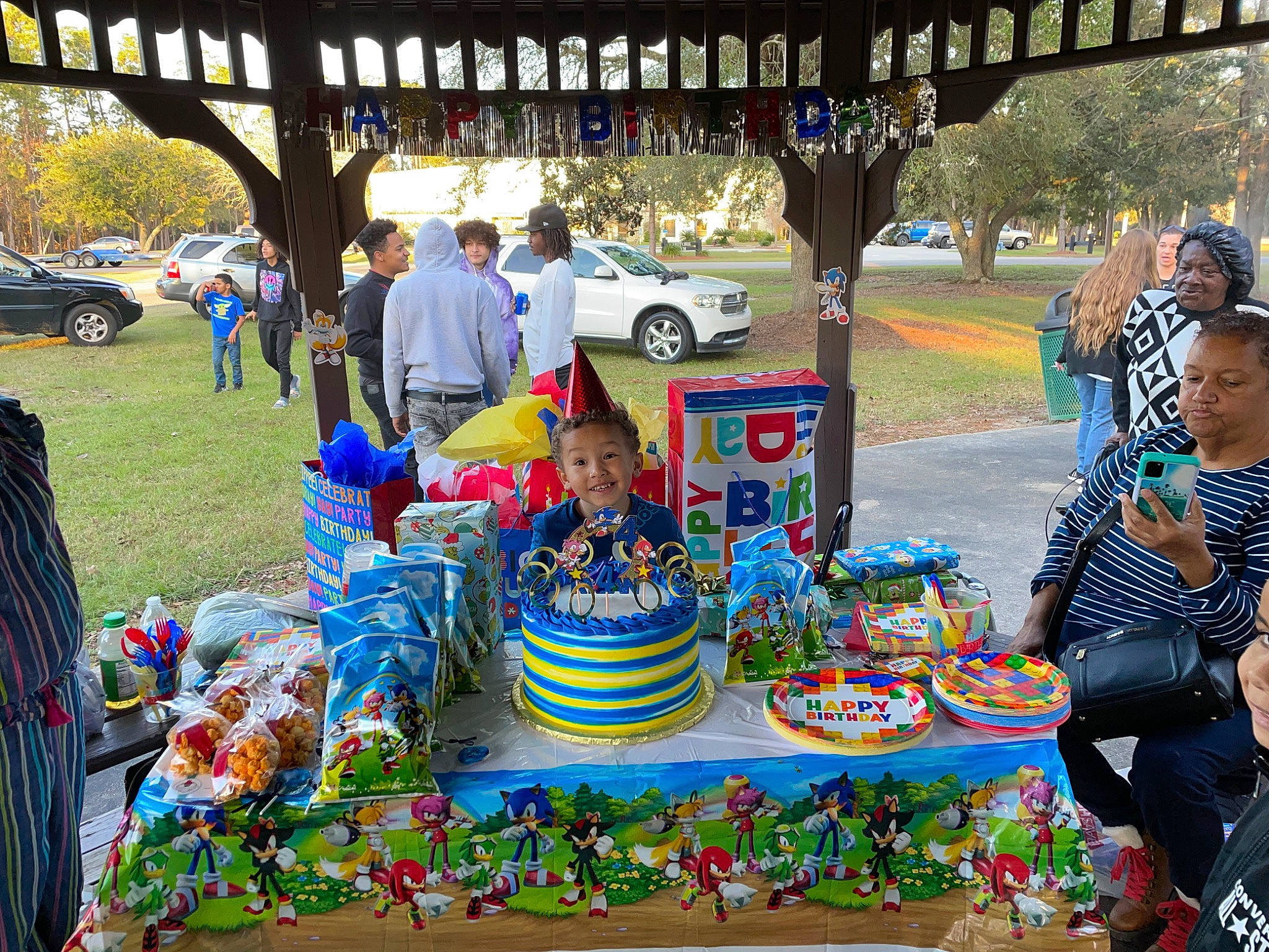 Rylan is registered to the contest to win money with this photo: automotive_wheel_system, car, chair, city, crowd, event, fun, hat, headwear, human_settlement, joy, leisure, market, motor_vehicle, person, plant, public_space, recreation, summer, tire