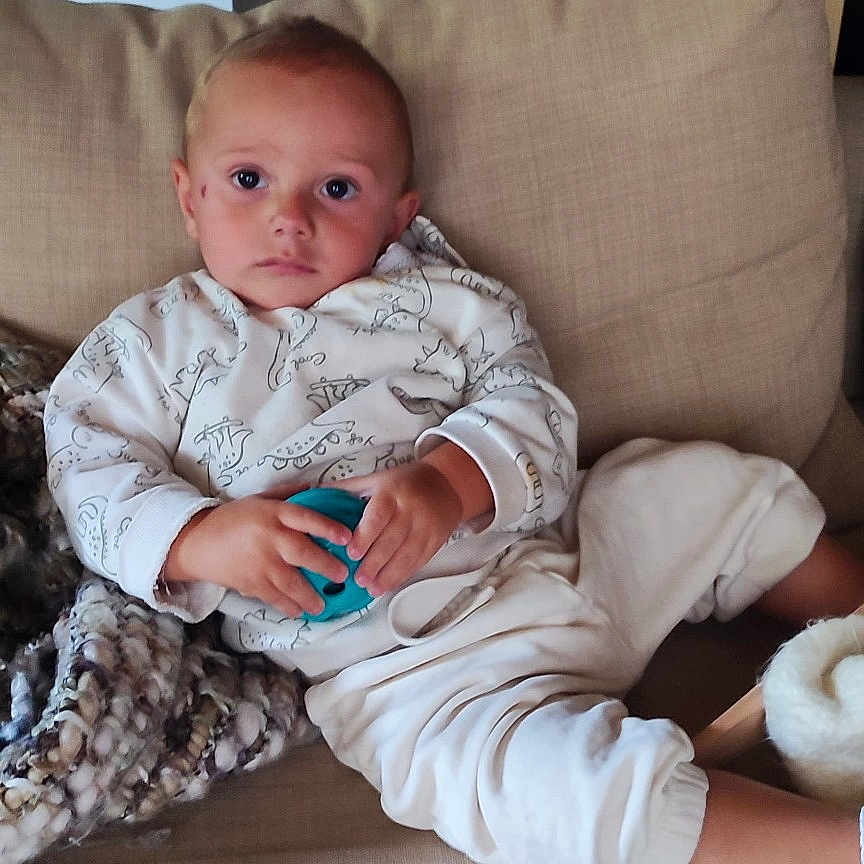 Canelo a rejoint le concours — aidez-le/la à gagner de superbes lots ! blanket, casual, child, clothing, couch, face, footwear, furniture, hand, home, indoors, living_room, pajamas, person, portrait, relaxing, sofa, toddler, toy, young_child