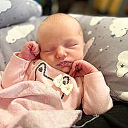 Hazel is registered to the contest to win money with this photo: baby, newborn, sleeping, pink_clothing, bow, blanket, pillow, cloud_pattern, face, infant, peaceful, cute, soft, hands, cozy, indoors, portrait, child, resting, toddler