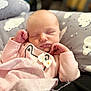 baby, newborn, sleeping, pink_clothing, bow, blanket, pillow, cloud_pattern, face, infant, peaceful, cute, soft, hands, cozy, indoors, portrait, child, resting, toddler