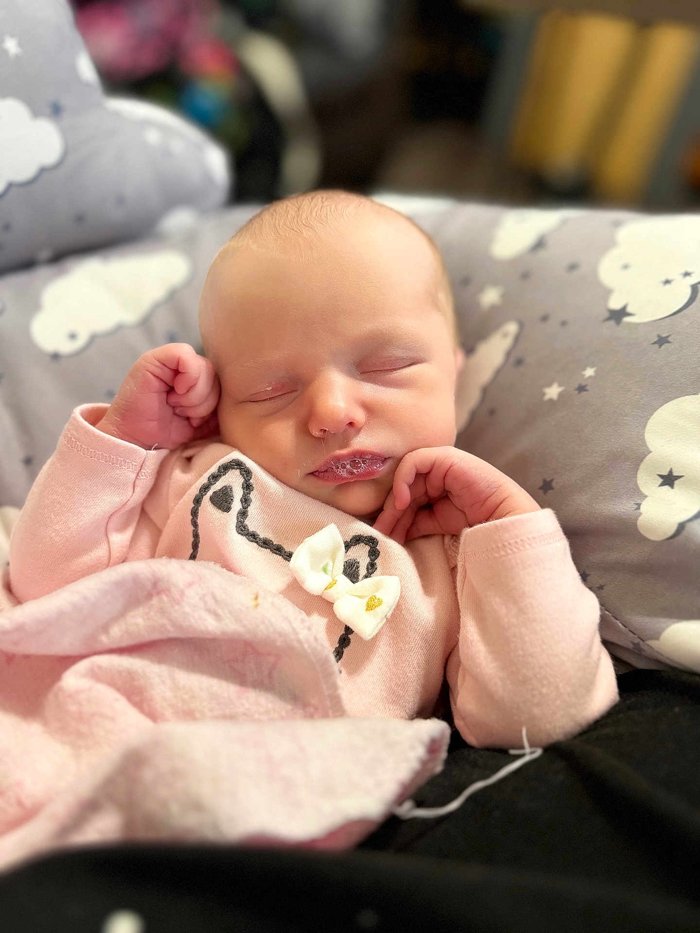 Hazel is registered to the contest to win money with this photo: baby, newborn, sleeping, pink_clothing, bow, blanket, pillow, cloud_pattern, face, infant, peaceful, cute, soft, hands, cozy, indoors, portrait, child, resting, toddler