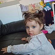 Lucianna joined the competition — help win amazing prizes! toddler, child, blue_eyes, white_dress, pigtails, couch, leather, plush_toys, stuffed_animals, nursery, wall_decor, elephant_sticker, teddy_bear, carpet, indoor, person, home, cute, curious, playful