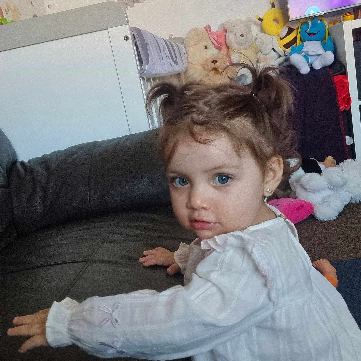 Lucianna joined the competition — help win amazing prizes! blue_eyes, carpet, child, couch, curious, cute, elephant_sticker, home, indoor, leather, nursery, person, pigtails, playful, plush_toys, stuffed_animals, teddy_bear, toddler, wall_decor, white_dress