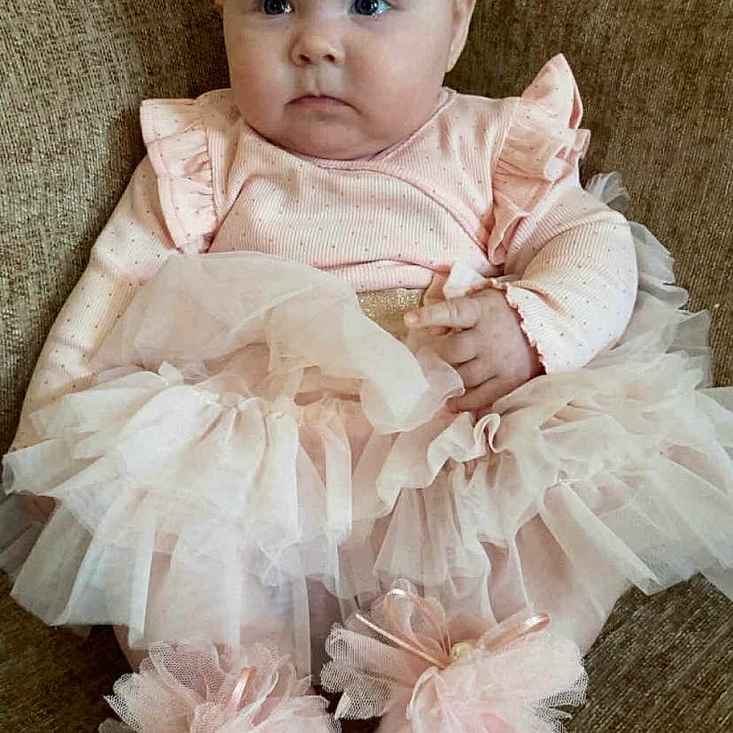 Ariana Maeve joined the competition — help win amazing prizes! adorable, baby, child, couch, cute, dress, fashion, footwear, headband, indoor, infant, pink_bow, portrait, pretty, ruffles, sitting, small, soft_toys, tutu, young_child