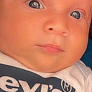 Alexander is registered to the contest to win money with this photo: baby, closeup, face, infant, levis, shirt, clothing, eyes, skin, portrait, cute, young, child, expression, human, newborn, indoors, soft_light, curious, head