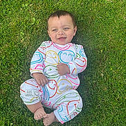 Stalin is registered to the contest to win money with this photo: baby, infant, grass, smile, happy, outdoor, onesie, colorful_clothing, child, cute, face, barefoot, nature, playful, young, person, joyful, greenery, relaxed, casual