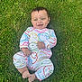 baby, infant, grass, smile, happy, outdoor, onesie, colorful_clothing, child, cute, face, barefoot, nature, playful, young, person, joyful, greenery, relaxed, casual