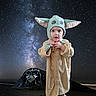 baby_yoda_hat, beach, child, cosplay, costume, cute, darth_vader_graffiti, eyes, face, galaxy, hat, hood, milky_way, night, outdoor, portrait, rock, starry_sky, stars, toddler