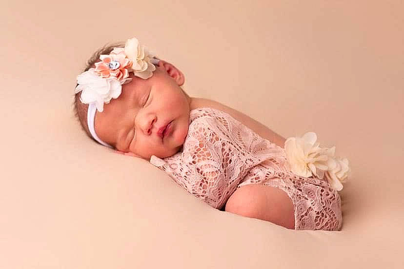Avah participe au concours pour gagner de l'argent avec cette photo : baby, baby_toddler_clothing, child, comfort, dress, embellishment, fashion_accessory, flash_photography, hair_accessory, happy, headband, headpiece, headwear, jewellery, pattern, peach, person, petal, pink, portrait_photography