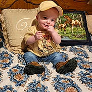 Logan is registered to the contest to win money with this photo: animal, baby, baseballcap, bed, cap, clothing, cushion, face, footwear, furniture, hat, head, homedecor, jeans, pants, person, photography, portrait, shoe, sitting