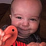 Logan is registered to the contest to win money with this photo: baby, bodypart, couch, cushion, cutlery, face, finger, furniture, hand, happy, head, homedecor, laughing, mouth, person, photography, portrait, smile, spoon, teeth