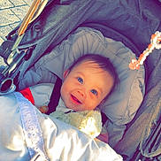 Mila joined the competition — help win amazing prizes! baby, bed, bonnet, city, clothing, coat, crib, face, furniture, hat, head, infantbed, jacket, person, photography, portrait, road, street, stroller, urban