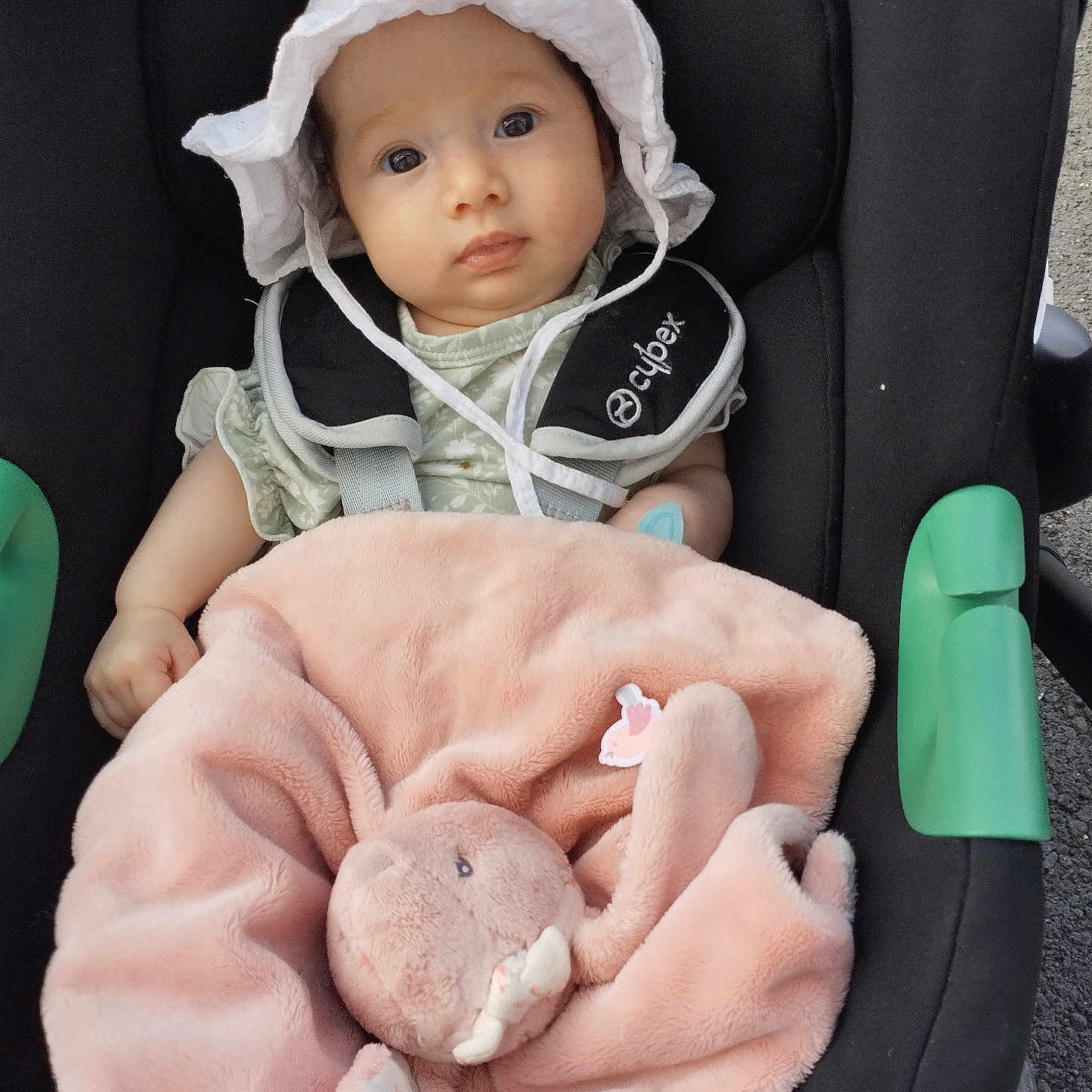 Mayna participe au concours pour gagner de l'argent avec cette photo : baby, baby_clothes, blanket, bunny, car_seat, child, cute, daylight, face, hat, infant, looking, outdoor, person, pink_blanket, plush_toy, safety_harness, seat_belt, soft_toy, white_hat
