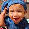 toddler, child, blue_hat, smiling, indoor, playpen, colorful, patterned, baby_clothes, furniture, living_room, hand, face, expression, cute, portrait, young_child, person, happy, headwear