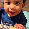 toddler, child, blue_hat, blue_shirt, smiling, hand, patterned_rail, indoor, playpen, baby, cute, happy, face, portrait, young_child, person, clothing, socks, colorful, grip