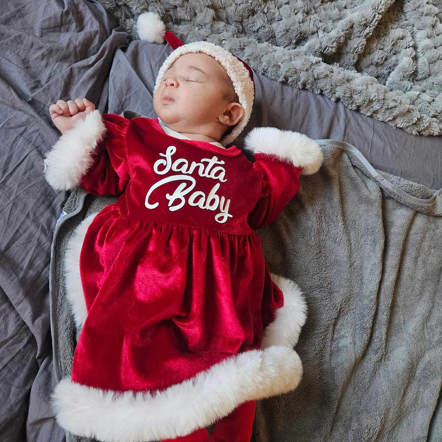 Laïana a rejoint le concours — aidez-le/la à gagner de superbes lots ! baby, blanket, child, christmas, cozy, cute, fabric, festive, fur_trim, hat, holiday, indoors, infant, lying_down, peaceful, portrait, red_dress, santa_baby, sleeping, soft_texture