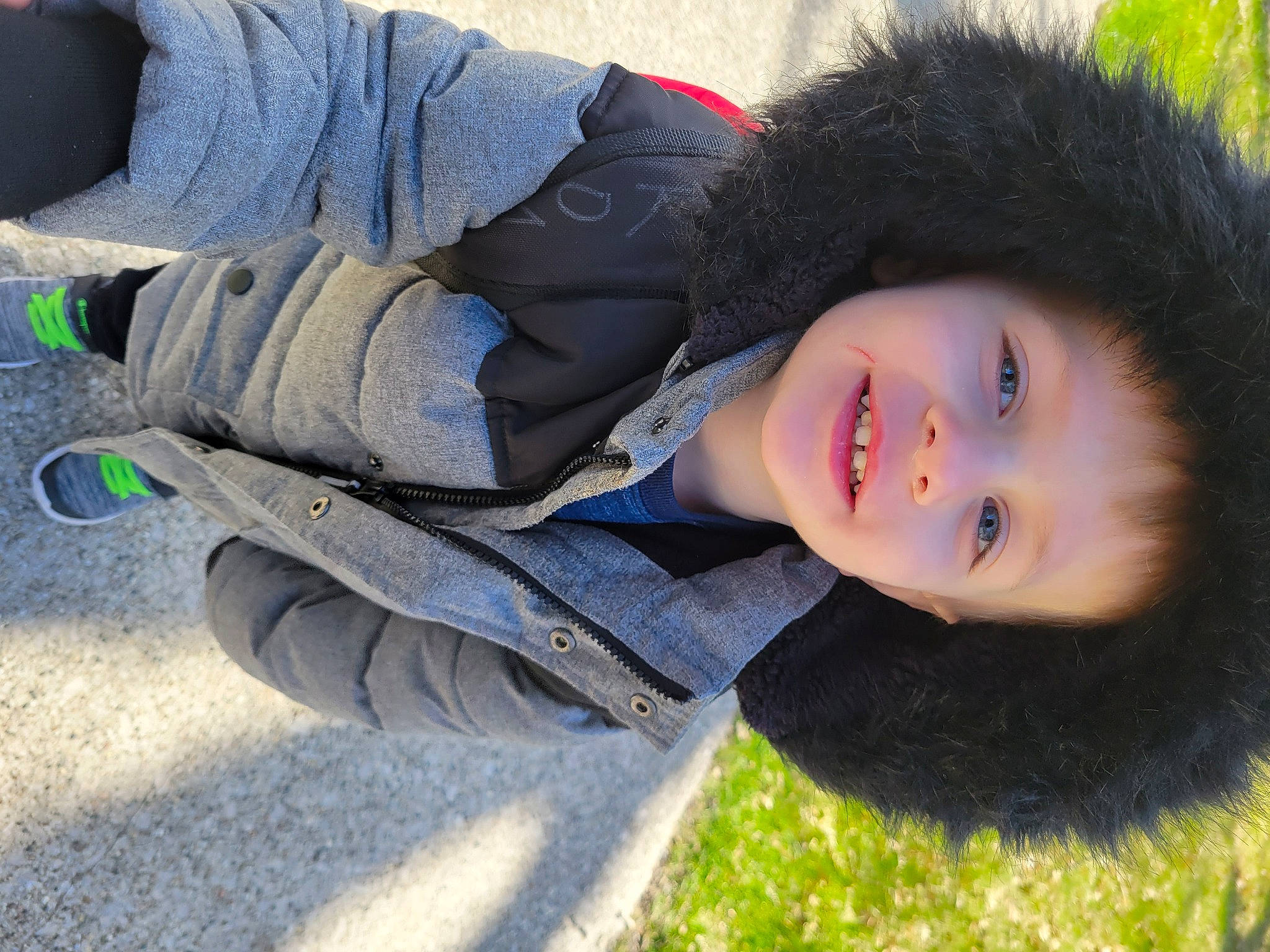 Roman is registered to the contest to win money with this photo: child, comfort, cool, denim, electric_blue, eye, flash_photography, fun, fur, grass, happy, headgear, joy, lip, person, plant, portrait_photography, sitting, smile, street_fashion