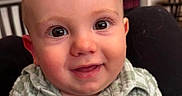 Zephaniah is registered to the contest to win money with this photo: baby, child, smiling, face, eyes, shirt, green, plaid, indoor, home, person, portrait, cute, happy, infant, young, head, skin, button, background