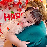 Reyna is registered to the contest to win money with this photo: baby, child, person, arm, hair, balloon, party, celebration, dress, bow, face, skin, hand, hug, adult, background, decoration, photo, red, white