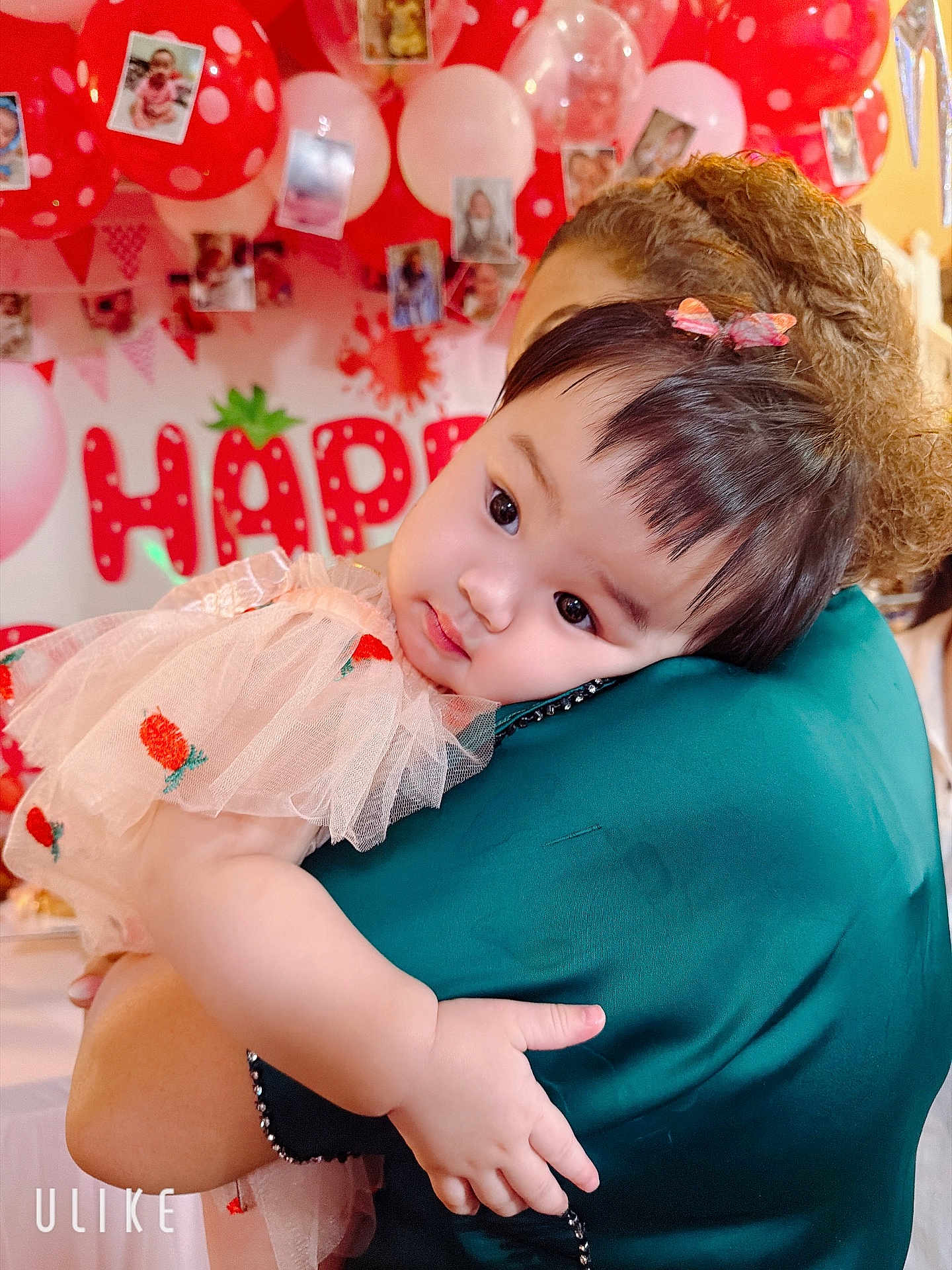 Reyna is registered to the contest to win money with this photo: baby, child, person, arm, hair, balloon, party, celebration, dress, bow, face, skin, hand, hug, adult, background, decoration, photo, red, white