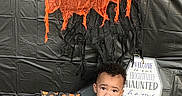 Zaydin is registered to the contest to win money with this photo: baby, clothing, costume, face, festival, flower, flowerarrangement, food, halloween, head, person, photography, plant, portrait, pottedplant, produce, pumpkin, purple, squash, vegetable