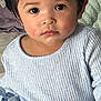 Jaylannie joined the competition — help win amazing prizes! toddler, child, face, hair, sweater, knitted, blue, indoor, sitting, blanket, cushion, person, portrait, skin, hand, clothing, young_child, cute, expression, cozy