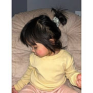 Jaylannie is registered to the contest to win money with this photo: child, toddler, pigtail, scrunchie, yellow_sweater, pajamas, indoor, cushion, plush, sitting, profile, rosy_cheeks, hair, bangs, hand, portrait, flash_photography, cozy, bokeh, face