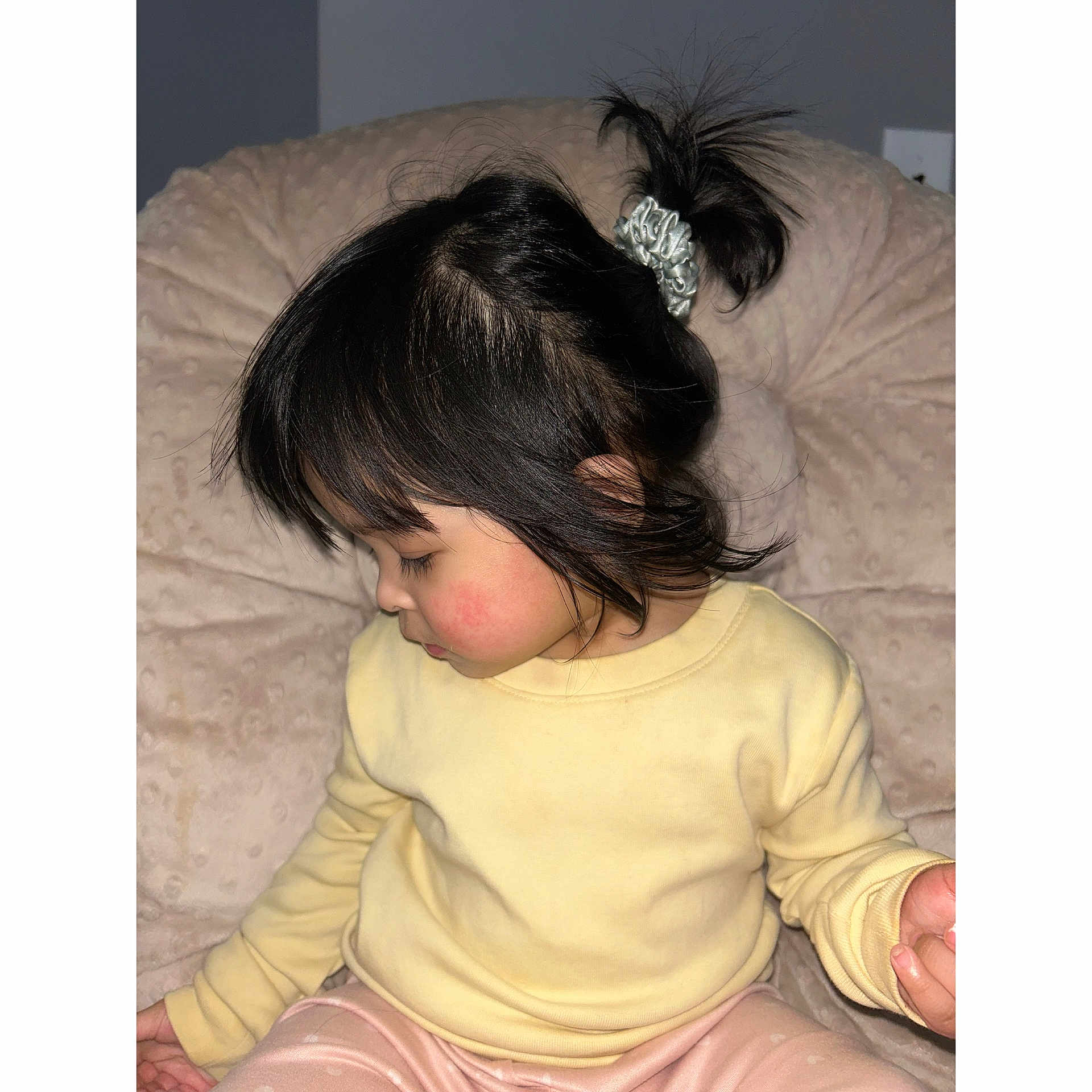 Jaylannie is registered to the contest to win money with this photo: child, toddler, pigtail, scrunchie, yellow_sweater, pajamas, indoor, cushion, plush, sitting, profile, rosy_cheeks, hair, bangs, hand, portrait, flash_photography, cozy, bokeh, face