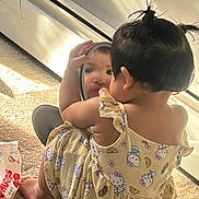 Jaylannie joined the competition — help win amazing prizes! toddler, child, mirror, reflection, yellow_dress, hello_kitty, pigtails, carpet, sunlight, indoor, baby, curious, diapers, package, window_light, cute, sitting, self_discovery, playful, home