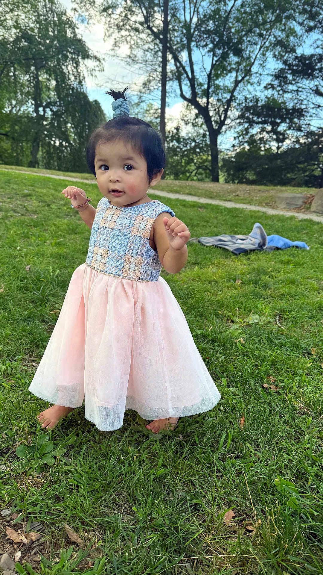 Jaylannie joined the competition — help win amazing prizes! toddler, child, barefoot, dress, grass, outdoor, park, trees, sky, young_child, curious, person, nature, daylight, small_pony_tail, greenery, casual, cute, portrait, standing