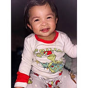 Jaylannie is registered to the contest to win money with this photo: toddler, child, smiling, pajamas, grinch, clothing, face, portrait, happy, indoors, baby, cute, young_child, sitting, long_sleeve, festive, holiday, red_trim, cozy, cute_expression