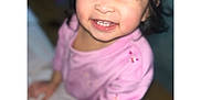 Jaylannie is registered to the contest to win money with this photo: child, toddler, smiling, teeth, pink_shirt, bangs, dark_hair, portrait, closeup, indoor, flash, candid, joyful, chubby_cheeks, squinting_eyes, hand, clothing, skin, sitting, happy