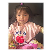Jaylannie is registered to the contest to win money with this photo: child, toddler, pink_shirt, apple_graphic, colorful_pants, pony_tail, sitting, indoor, cute, person, smiling, face, young_child, casual_clothing, patterned_pants, bright_colors, happy, portrait, playful, cozy