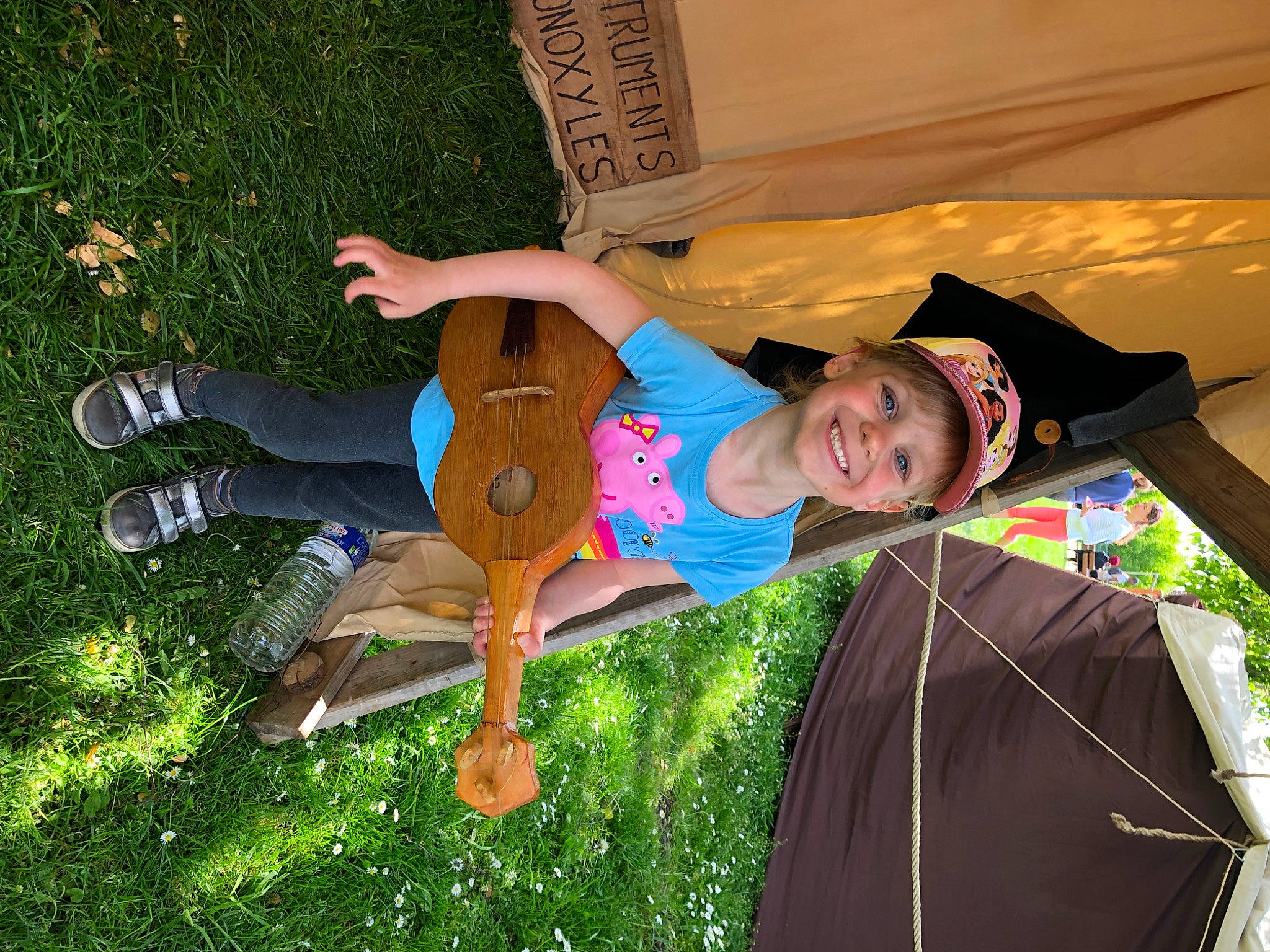 Maïna a rejoint le concours — aidez-le/la à gagner de superbes lots ! chair, child, cool, fashion_accessory, fun, grass, grassland, happy, human_leg, joy, knee, landscape, leisure, people_in_nature, person, recreation, sandal, shorts, sitting, smile