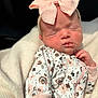 baby, newborn, infant, headband, pink_bow, sleeping, closed_eyes, onesie, floral_pattern, blanket, soft_texture, cheeks, lips, hand, portrait, cozy, wrapped, skin, nursery, peaceful