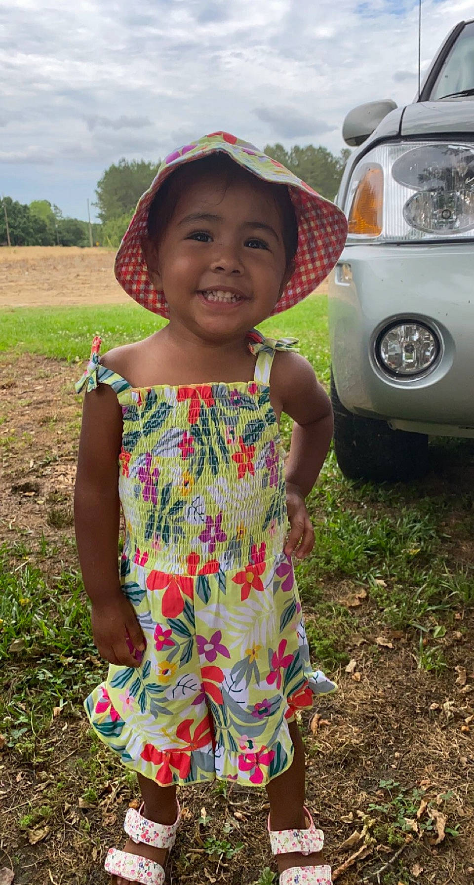 Verenice joined the competition — help win amazing prizes! automotive_exterior, automotive_lighting, automotive_tire, car, cloud, dress, grass, happy, joy, light, motor_vehicle, natural_environment, person, plant, public_space, smile, summer, toddler, tree, vehicle