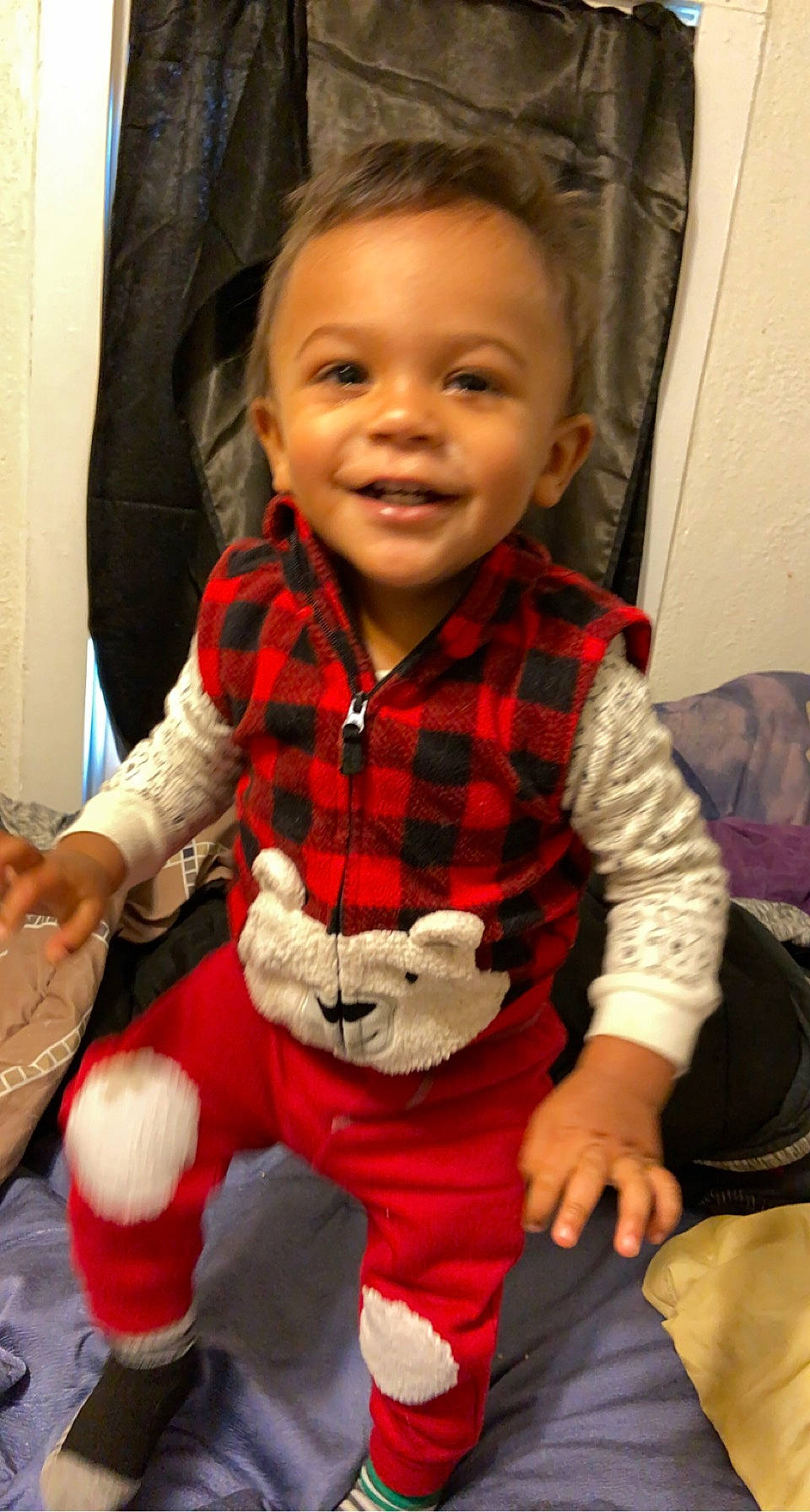 Andre is registered to the contest to win money with this photo: baby_toddler_clothing, cheek, child, eye, facial_expression, fun, happy, joy, lap, organ, pattern, person, plaid, skin, sleeve, smile, sock, tartan, textile, thumb