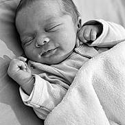 Ezio participe au concours pour gagner de l'argent avec cette photo : baby, newborn, sleeping, blanket, infant, peaceful, black_and_white, portrait, soft_texture, cute, clothing, hand, face, closeup, resting, child, toddler, indoors, cozy, smile