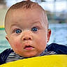 baby, blue_eyes, child, closeup, curious, cute, face, floatation_device, indoor, infant, person, pool, portrait, rosy_cheeks, splash, striped_shirt, swimming, water, wet, yellow