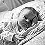 Ezio participe au concours pour gagner de l'argent avec cette photo : baby, newborn, infant, blanket, bed, sleeping, hand, face, cozy, monochrome, black_and_white, cute, portrait, resting, soft, clothing, indoors, expression, child, person