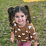 child, girl, smiling, pigtails, sweater, hearts, pink_leggings, outdoor, grass, playful, cute, happy, young, portrait, casual_clothing, daylight, person, fashion, fun, nature