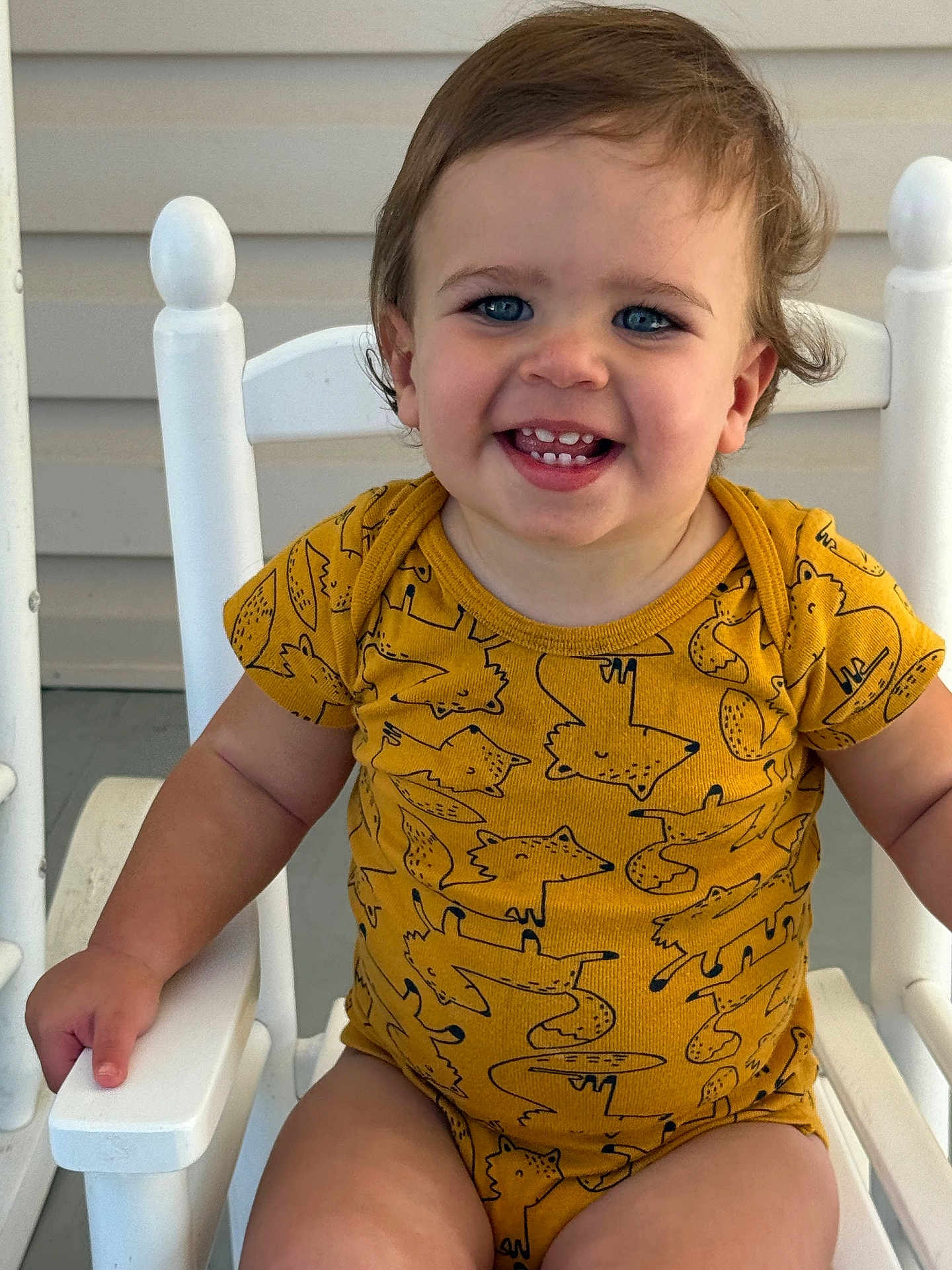 Jace joined the competition — help win amazing prizes! toddler, child, smiling, blue_eyes, yellow_onesie, fox_pattern, rocking_chair, white_chair, curly_hair, happy, portrait, baby, indoor, cute, sitting, closeup, skin, face, arm, hand