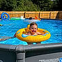 Jace joined the competition — help win amazing prizes! child, toddler, pool, swim_ring, water, outdoor, summer, sunlight, fence, inflatable, toy, smile, happy, blue_sky, trees, swimming, fun, play, vacation, curly_hair