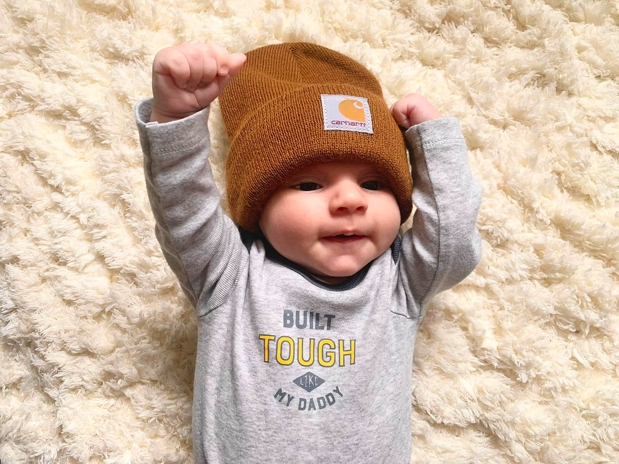Liam joined the competition — help win amazing prizes! baby, baby_toddler_clothing, beanie, cap, comfort, face, fashion_accessory, fun, happy, head, headwear, knit_cap, mammal, person, sleeve, smile, t_shirt, textile, toddler, wood
