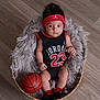baby, basket, basketball, basketball_jersey, headband, floor, infant, indoors, person, plush, cute, sportswear, socks, wood_floor, portrait, child, resting, soft_texture, red_black, small_basketball